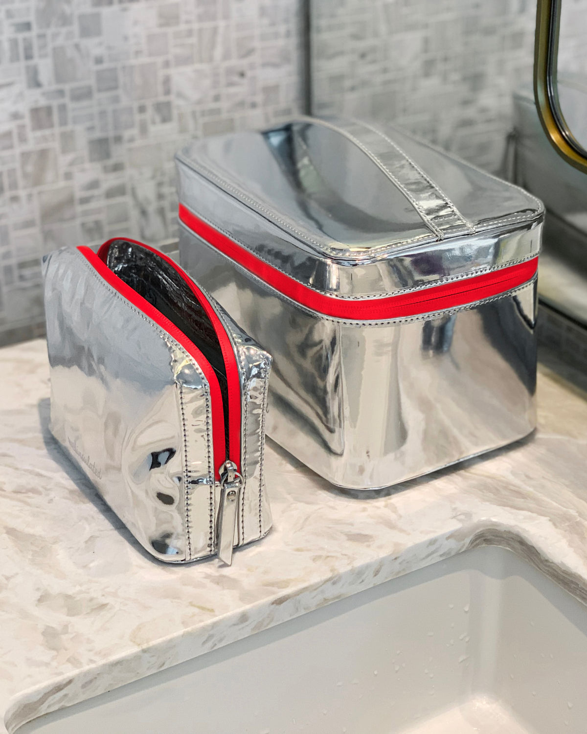 Limited Edition Red WELLinsulated Beauty Bag and Case on luxury marble bathroom counter.